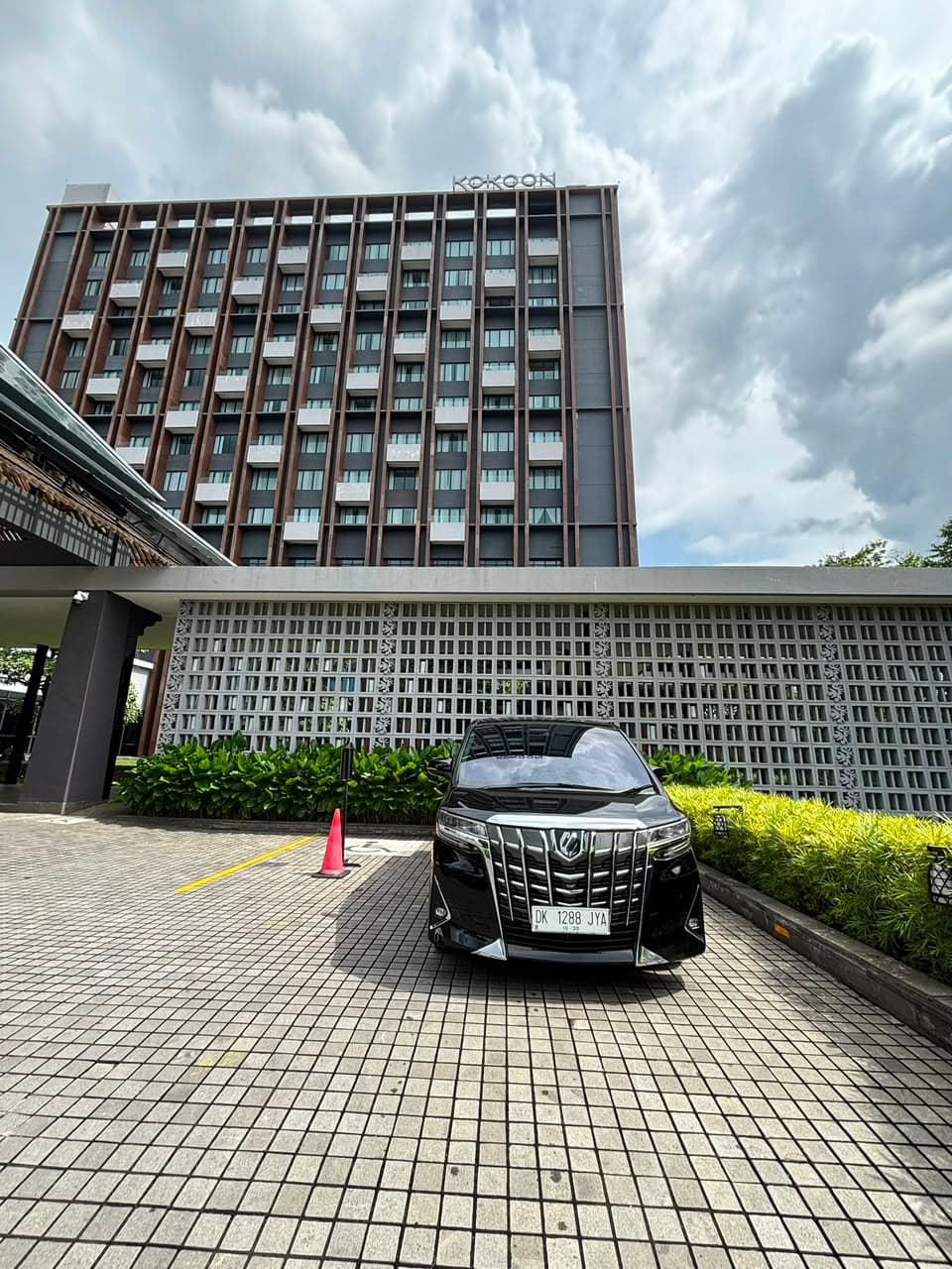 Toyota Alphard hitam LUGAYA terparkir di depan hotel